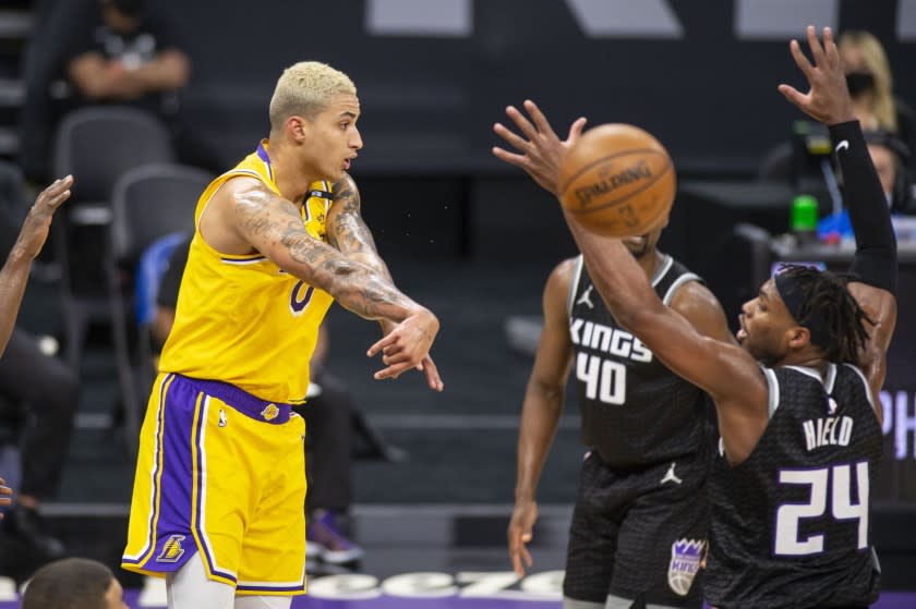 Los Angeles Lakers forward Kyle Kuzma (0) passes the ball past Sacramento Kings guard Buddy Hield (24) during the second quarter of an NBA basketball game in Sacramento, Calif., Friday, April 2, 2021. (AP Photo/Hector Amezcua)