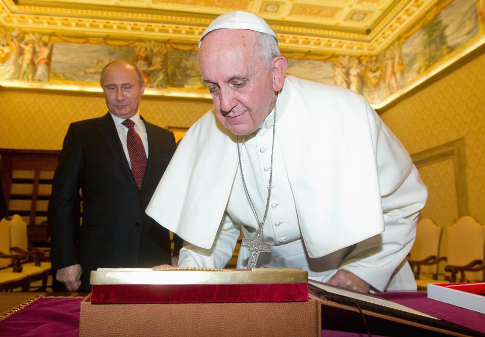 Pope Francis (R) exchanges gifts with Russia's President Vladimir Putin during a private audience at the Vatican, November 25, 2013. REUTERS/Claudio Peri/Pool (VATICAN - Tags: RELIGION POLITICS)