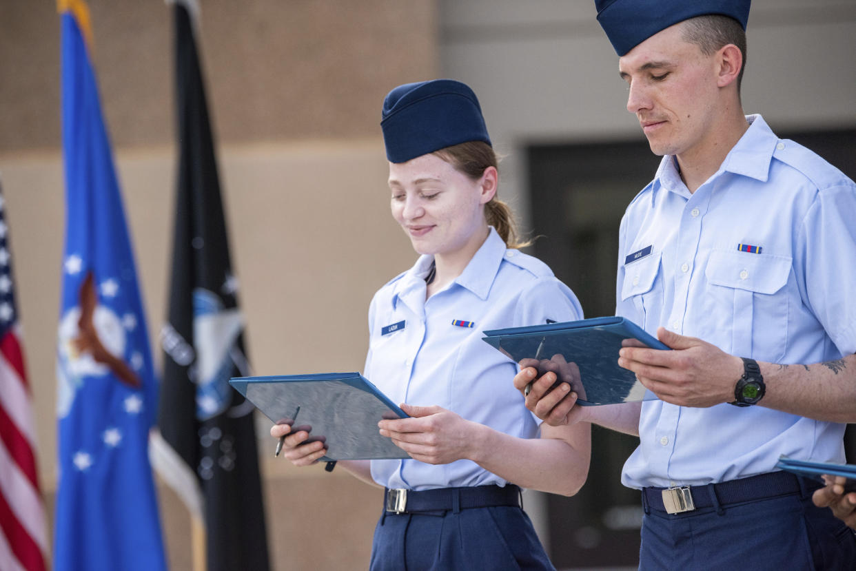 Airman 1st Class Natalia Laziuk, from Russia, left, and Airman 1st Class Ross Mudie, from South Africa, look at their U.S. Certificates of Citizenship after signing it following the Basic Military Training Coin Ceremony on April 26, 2023, at Joint Base San Antonio-Lackland, Texas. (Christa D'Andrea/U.S. Air Force via AP)