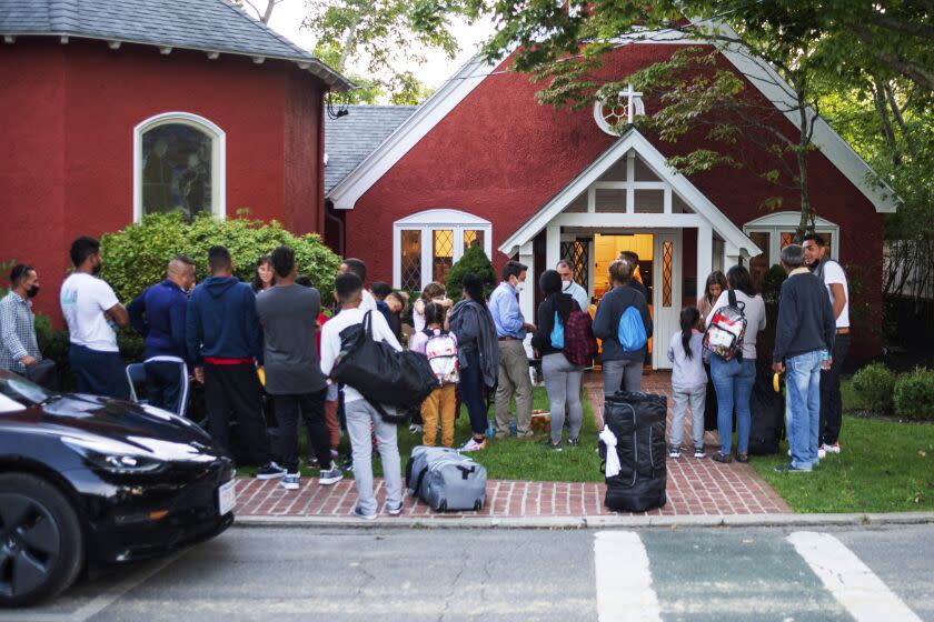 Inmigrantes se congregan en las afueras de la Iglesia Episcopal St. Andrews en Martha's Vineyard el 14 de septiembre del 2022. El gobernador de Florida Ron DeSantis envió dos vuelos con inmigrantes a Martha's Vineyard, escalando una táctica de gobernadores republicanos para atraer atención a lo que llaman políticas fallidas de inmigración del presidente Joe Biden. (Ray Ewing/Vineyard Gazette via AP)