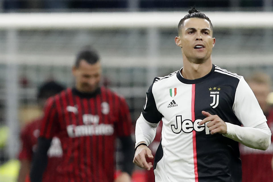 Juventus' Cristiano Ronaldo celebrates after scoring with penalty against AC Milan during an Italian Cup soccer match between AC Milan and Juventus at the San Siro stadium, in Milan, Italy, Thursday, Feb. 13, 2020. AC Milan's Zlatan Ibrahimovic is seen in the background. (AP Photo/Antonio Calanni)