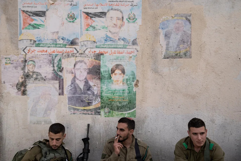 Israeli soldier carry ammunition next to a graffiti featuring the Palestinian flag, during an urban warfare exercise at an army training facility at the Zeelim army base, southern Israel, May 25, 2022.