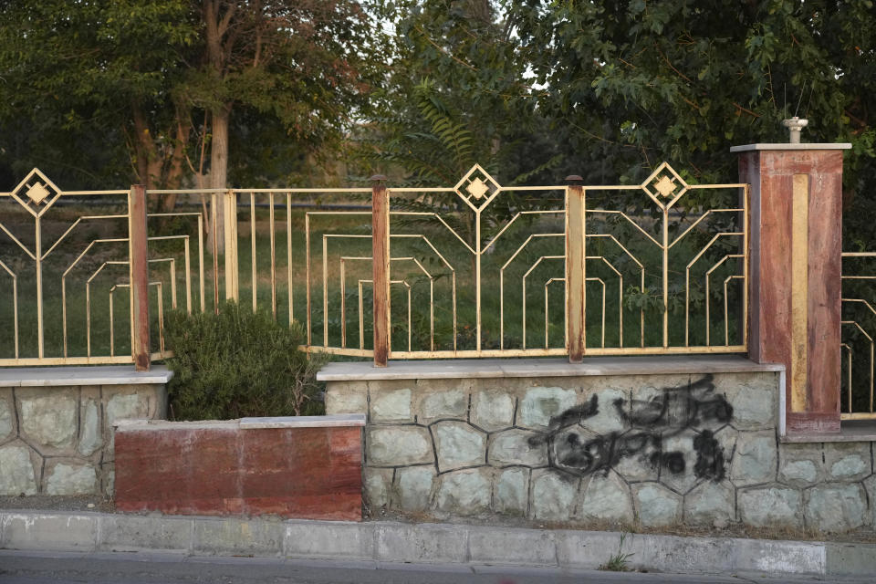 A graffiti against the government which is painted over in black is seen on the wall at a park in Tehran, Iran, Monday, Sept. 11, 2023. Iranians are marking the first anniversary of nationwide protests over the country's mandatory headscarf law that erupted after the death of a young woman detained by morality police. (AP Photo/Vahid Salemi)