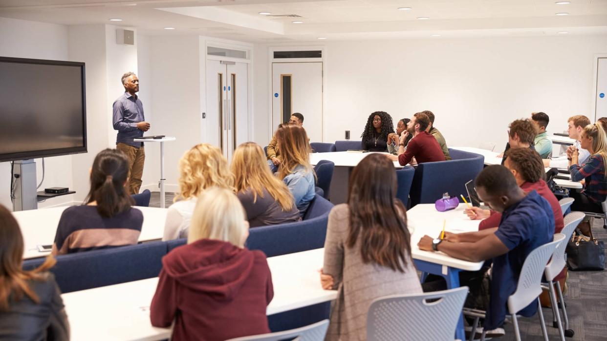 University students study in a classroom with male lecturer.