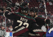 Arizona Coyotes' Nick Schmaltz (8) right, celebrates with Travis Boyd (72) after Boyd's goal against the Montreal Canadiens during the first period of an NHL hockey game Monday, Jan. 17, 2022, in Glendale, Ariz. (AP Photo/Darryl Webb)