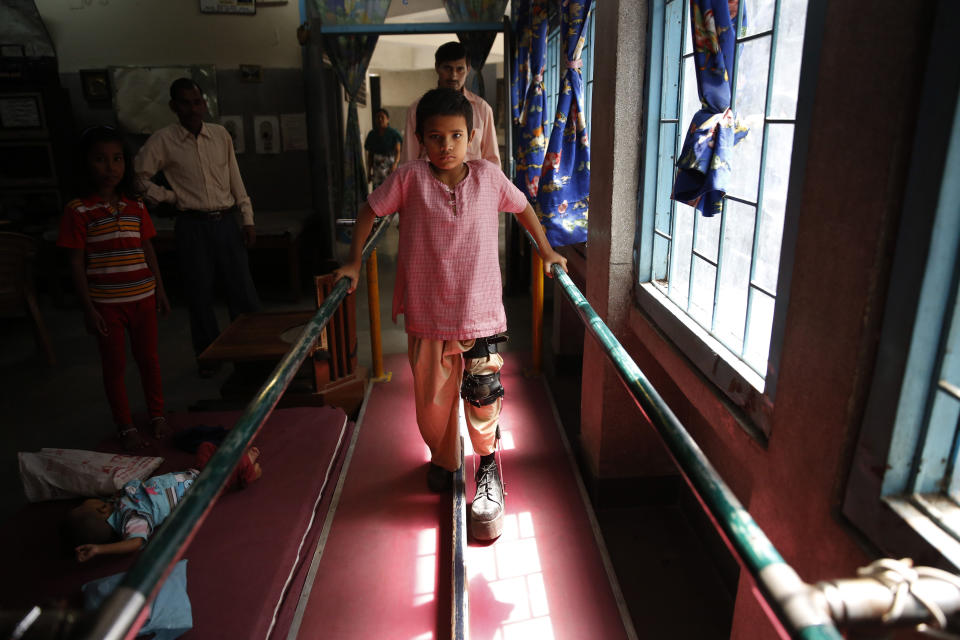 A polio-affected boy Manish, 8, learns to walk with his orthoses after a surgery at a physical rehabilitation center in New Delhi, India Thursday, March 27, 2014. The World Health Organization has formally declared India polio-free, with no new case of the disease detected in the country in the past three years. (AP Photo /Manish Swarup)