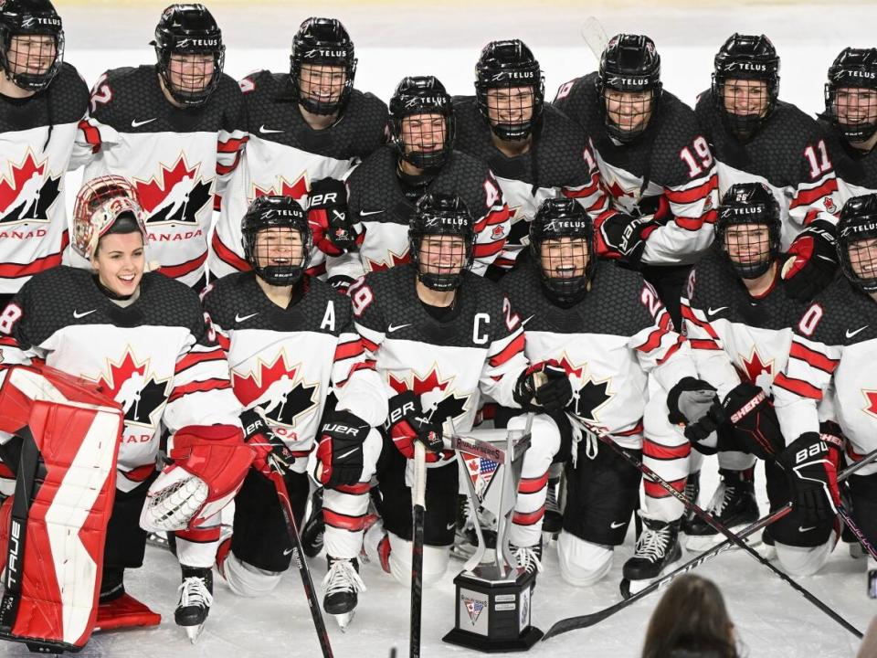 Canada's women's national hockey team celebrate with the trophy after defeating the U.S. 5-0 for a fourth straight win in best-of-seven Rivalry Series hockey in Laval, Que., Wednesday. (Graham Hughes/The Canadian Press - image credit)