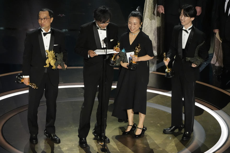 FILE - Masaki Takahashi, from left, Takashi Yamazaki, Kiyoko Shibuya, and Tatsuji Nojima accept the award for best visual effects for "Godzilla Minus One" during the Oscars on March 10, 2024, at the Dolby Theatre in Los Angeles. One Japanese creation grabbing attention on the Oscars red carpet wasn't a movie: the kitsch shoes that seemed to be clenched in Godzilla's claw. They were the work of Ryosuke Matsui, who recently described his joy at seeing “Godzilla Minus One” director Takashi Yamazaki and his Shirogumi special-effects team walk the red carpet and win the visual effects Oscar, all while wearing his shoes. (AP Photo/Chris Pizzello, File)