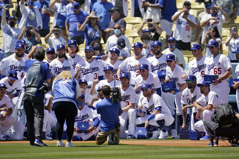 Members of the Los Angeles Dodgers pose for photos with their 2020 World Series Championship rings before a baseball game against the Washington Nationals Friday, April 9, 2021, in Los Angeles. (AP Photo/Marcio Jose Sanchez)
