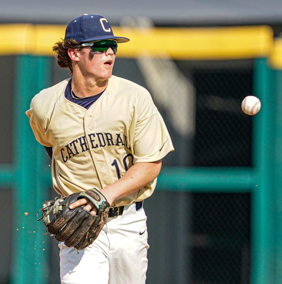 Cathedral High School's Ben Gomez (10) tosses the ball to a team mate behind his back after making a diving catch during the high school baseball City Tournament Championship Game between the Cathedral High School Fighting Irish and the Bishop Chatard Trojans on Tuesday, May 10, 2022, at Victory Field in Indianapolis.