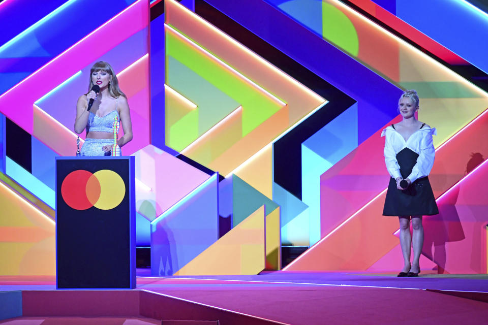 Taylor Swift accepts the Global Icon award as Maisie Williams looks on during the Brit Awards 2021 at the O2 Arena, in London, Tuesday, May 11, 2021. (Ian West/PA via AP)