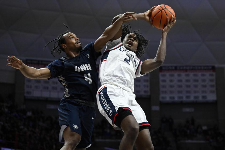 New Hampshire guard Ahmad Robinson (4) fouls UConn guard Tristen Newton (2) in the second half of an NCAA college basketball game, Monday, Nov. 27, 2023, in Storrs, Conn. (AP Photo/Jessica Hill)