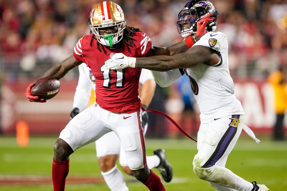 Brandon Aiyuk #11 of the San Francisco 49ers stiff-armed Patrick Queen #6 of the Baltimore Ravens during the fourth quarter at Levi's Stadium on December 25, 2023 in Santa Clara, California.