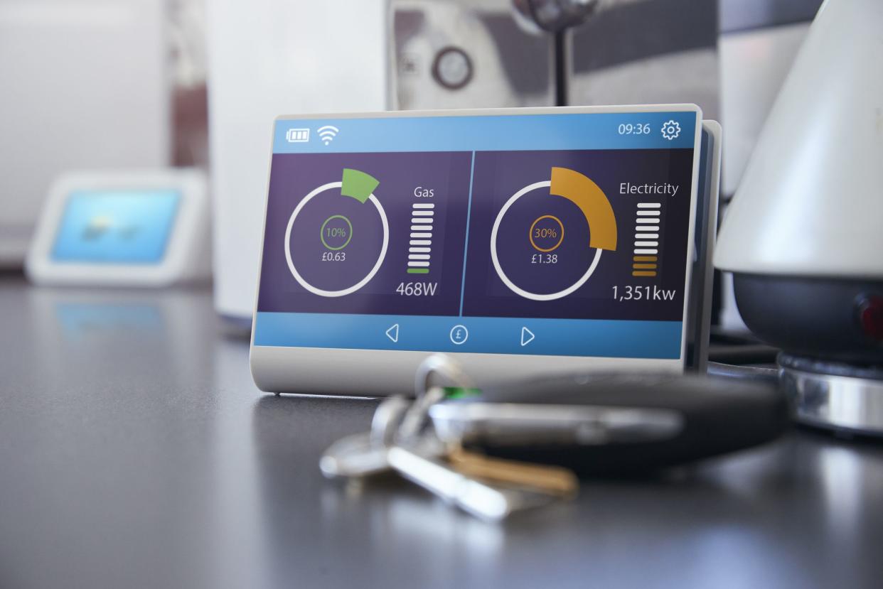 A smart meter on a kitchen work surface showing the households current energy consumption and costs