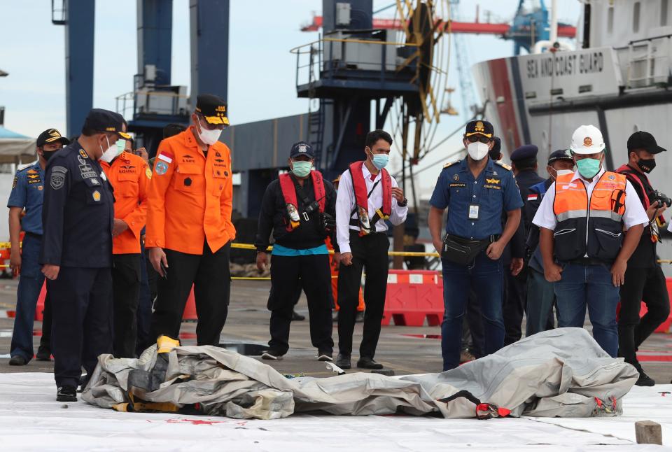 Searchers inspect debris found in the waters near where a Sriwijaya Air passenger jet lost contact with air traffic controllers shortly after takeoff.