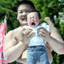 TOKYO, JAPAN: APRIL 29 A baby cries as a university sumo club members holds them during Crying-Sumo at Sensoji Temple April 29, 2004 in Tokyo, Japan. The baby that cries first wins the game. The ceremony has been taking place in Japan to wish for the good health of the child as it is said that crying is good for the health of babies. Majority of the children who participate are less than 1 year old. (Photo by Koichi Kamoshida/Getty Images)