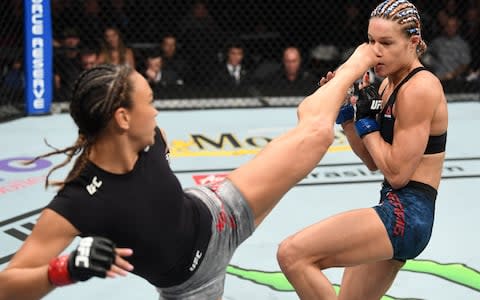 Michelle Waterson (l) kicks Felice Herrig in their women's strawweight bout - Credit: Zuffa LLC/Josh Hedges