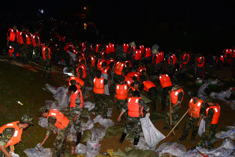 <p>Rescuers pile up sandbags to block flood waters at a flooded village in Yiyang, Hunan province, China, July 4, 2017. (Photo: Stringer/Reuters) </p>