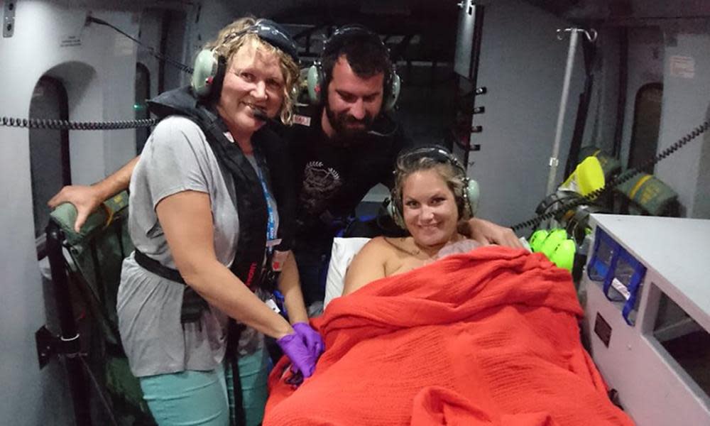 Alicia MacDonald holds baby Torran after giving birth in a coastguard helicopter, with midwife Linda Benson on the left.