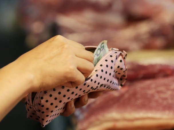 FILE PHOTO -  A customer takes a 50 Yuan note out as she pays for pork at a market in Beijing, August 12, 2015. REUTERS/Jason Lee/File Photo