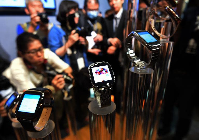 Journalists take photos of smart watches made by Taiwan's ASUSTeK Computer during the Computex trade show in Taipei, June 2, 2015