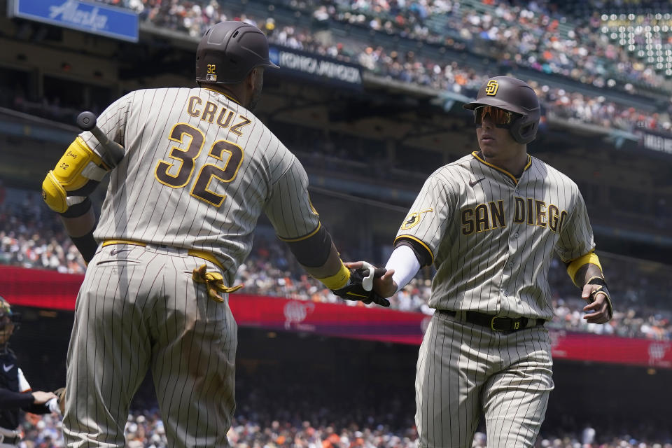 San Diego Padres' Manny Machado, right, is congratulated by Nelson Cruz after scoring against the San Francisco Giants during the fifth inning of a baseball game in San Francisco, Thursday, June 22, 2023. (AP Photo/Jeff Chiu)