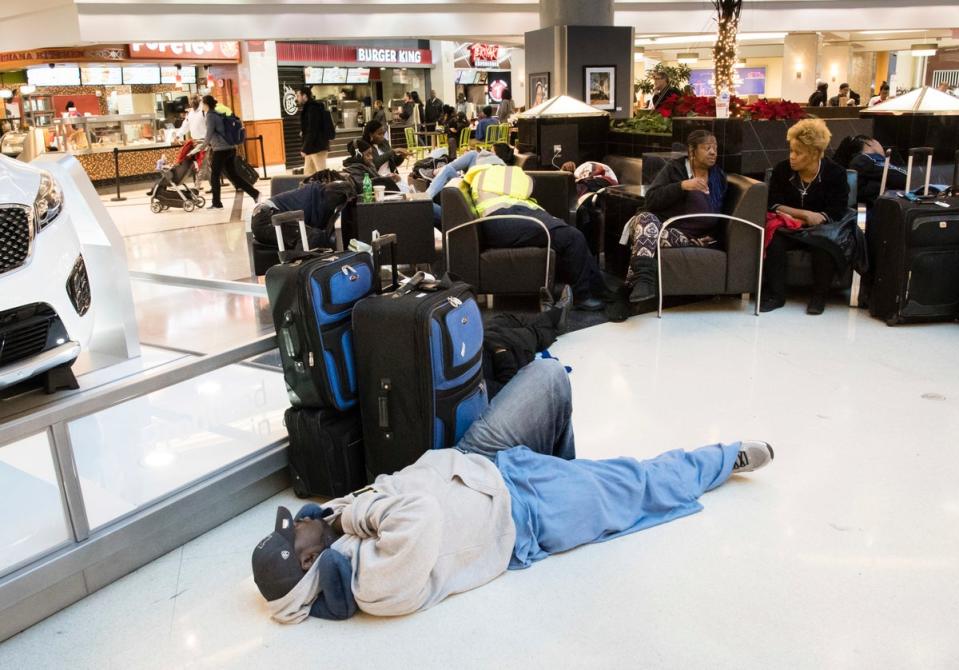 Un hombre duerme en el suelo en el aeropuerto de Atlanta (ASSOCIATED PRESS)