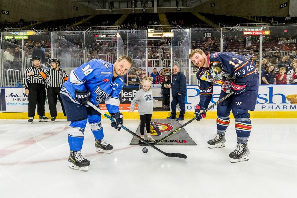 Peoria Rivermen captain Alec Hagaman and Pensacola captain Garrett Milan take a draw on a puck dropped by Hagaman's daughter, Adley, 5, during pre-game ceremonies on Saturday, April 8, 2023.