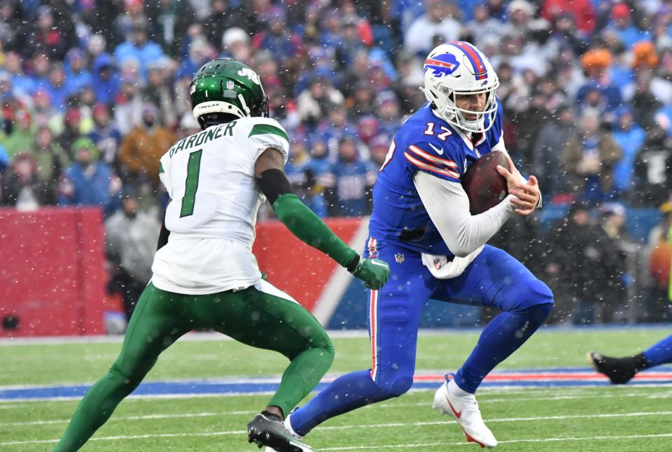 Dec 11, 2022; Orchard Park, New York, USA; Buffalo Bills quarterback Josh Allen (17) runs the ball against New York Jets cornerback Sauce Gardner (1) in the second quarter at Highmark Stadium. Mandatory Credit: Mark Konezny-USA TODAY Sports