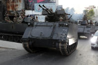 Lebanese army soldiers sit on their armored vehicles as they deployed to contain the tension after heavy fire in the coastal town of Khaldeh, south of Beirut, Lebanon, Sunday, Aug. 1, 2021. At least two people were killed on Sunday south of the Lebanese capital when gunmen opened fire at the funeral of a Hezbollah commander who was killed a day earlier, an official from the group said. (AP Photo/Bilal Hussein)