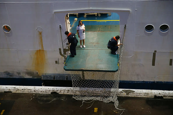 Crew members from the Ruby Princess can be seen as it docks at Overseas Passenger Terminal in Sydney, Australia. 