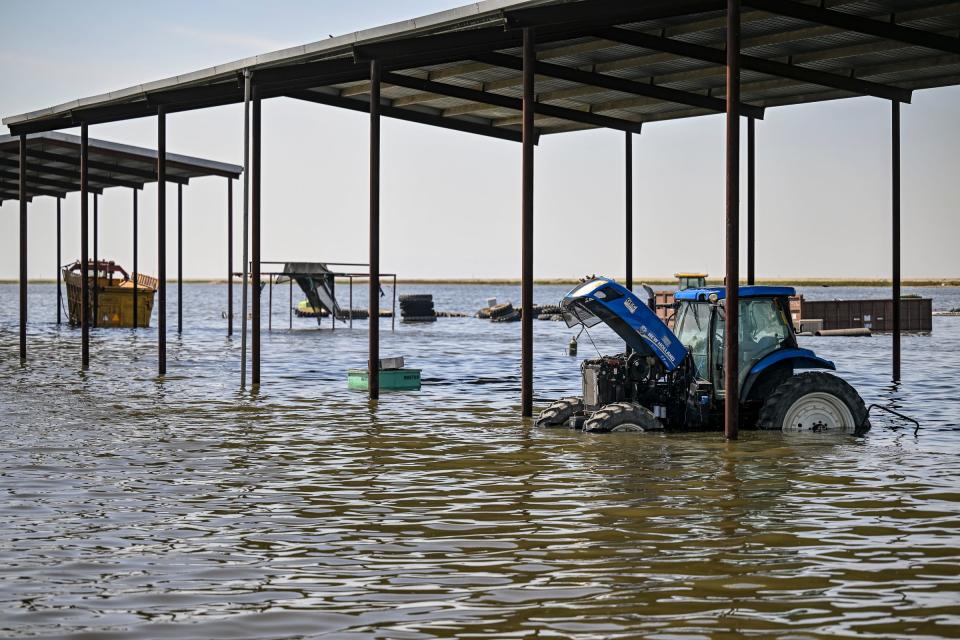 Partially submerged farm equipment at the edge of the flooded Tulare Lake south of the Tule River along Sixth Avenue in Corcoran, Calif. on Tuesday, April 25, 2023.