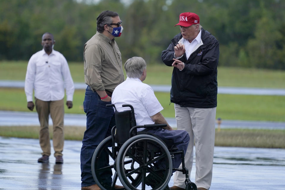 President Donald Trump talks with Texas Gov. Greg Abbott and Sen. Ted Cruz, R-Texas, as he arrives to view damage caused by Hurricane Laura, Saturday, Aug. 29, 2020, in Orange, Texas. (AP Photo/Alex Brandon)