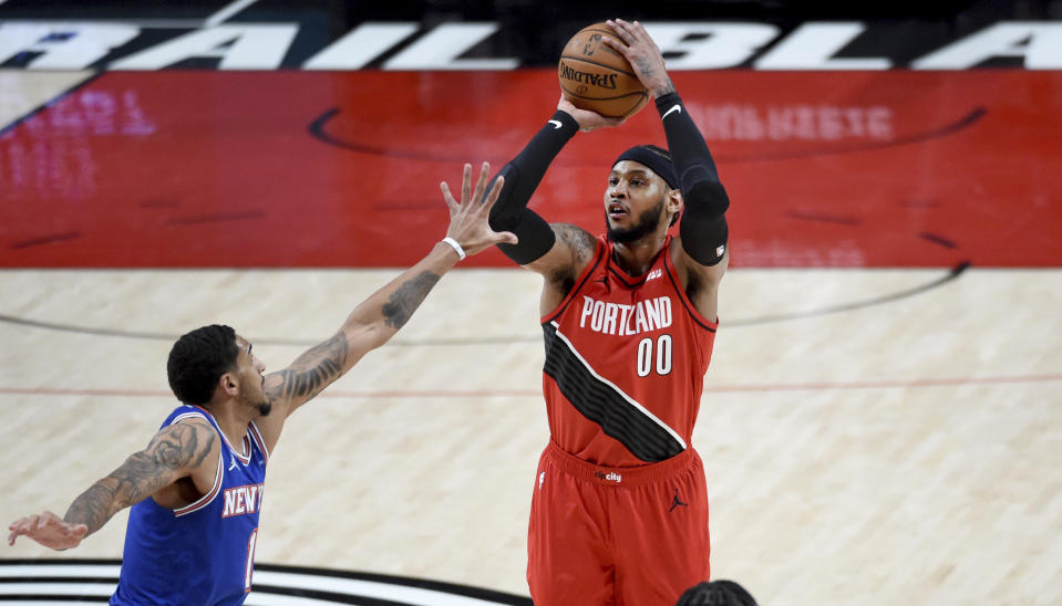 Portland Trail Blazers forward Carmelo Anthony, right, hits a shot over New York Knicks forward Obi Toppin, left, during the first half of an NBA basketball game in Portland, Ore., Sunday, Jan. 24, 2021. (AP Photo/Steve Dykes)