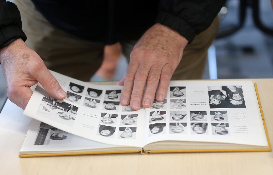 1974 alumni Ken James flips through a yearbook looking for his sister’s photo on Monday, March 25, 2024.