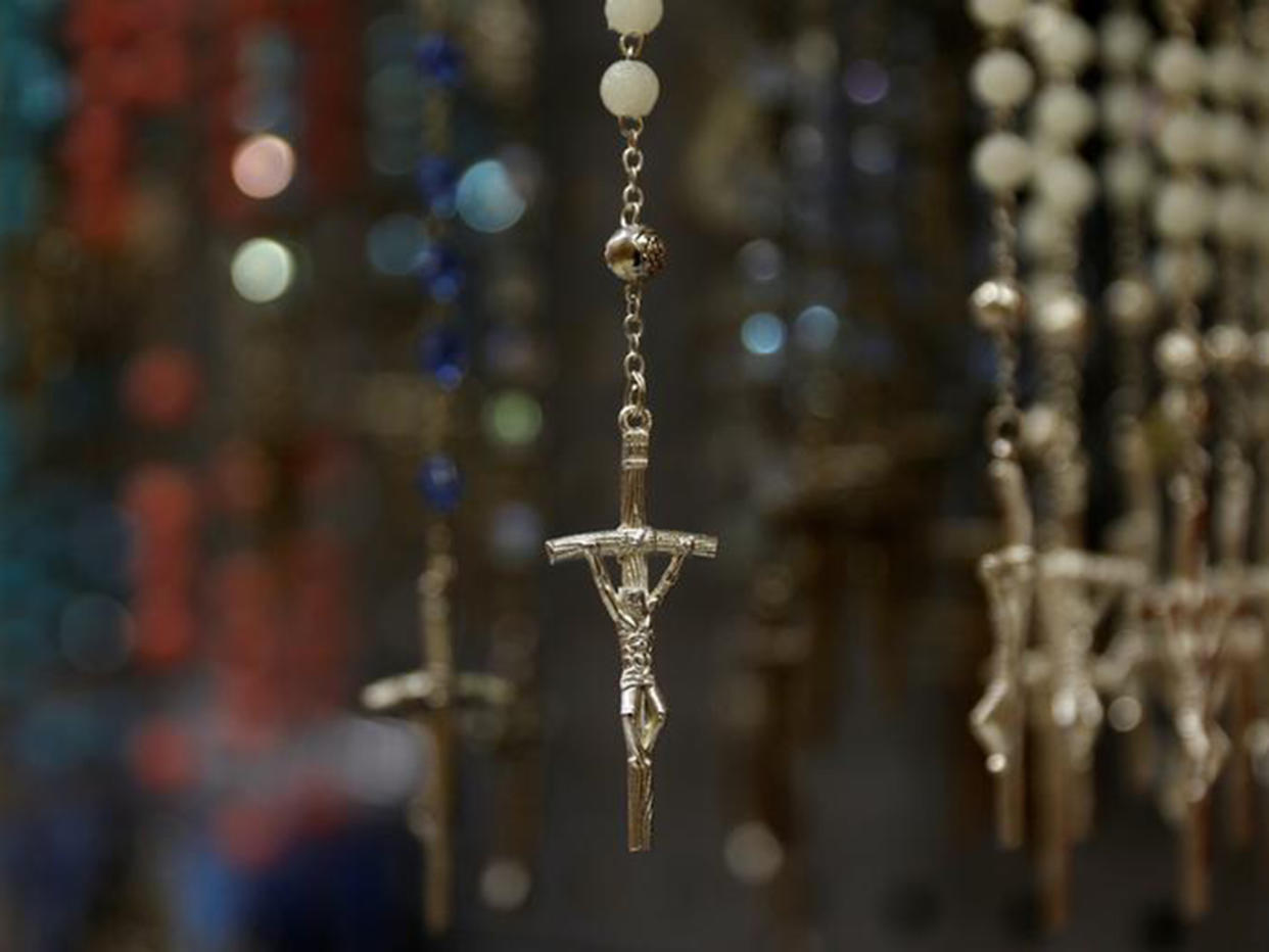 Crosses hang on the end of rosary beads displayed in a shop: REUTERS