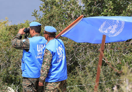 United Nations Interim Force in Lebanon (UNIFIL) peacekeepers watch as Israeli workers build a wall near the border with Israel, near the village of Naqoura, Lebanon March 6, 2018. REUTERS/Ali Hashisho