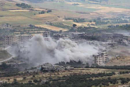 Smoke rises from buildings near the national hospital, where Syrian soldiers were holed up under siege by insurgents, after what activists said was shelling by warplanes loyal to Syria's President Bashar al-Assad in the town of Jisr al-Shughour, Idlib province May 22, 2015. REUTERS/Ammar Abdullah