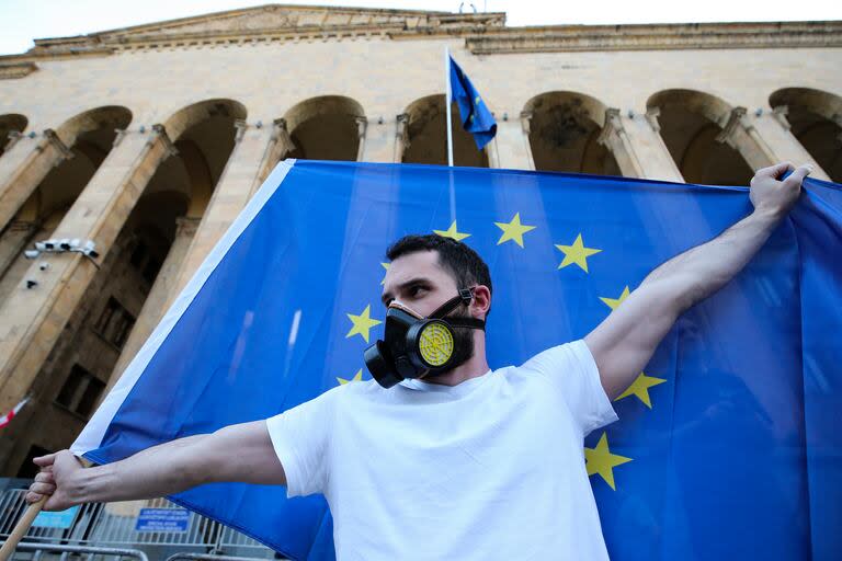 Un manifestante sostiene una bandera de la Unión Europea mientras participa en una protesta fuera del Parlamento, el miércoles 17 de abril de 2024, en Tiflis, Georgia. (AP Foto/Zurab Tsertsvadze)