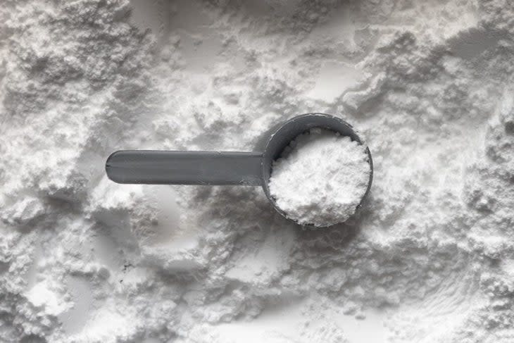 white powder of a supplement and a grey scoop