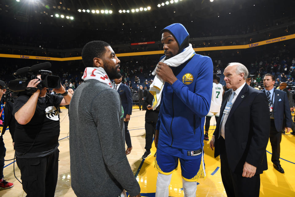 Kyrie Irving, left, and Kevin Durant, who will be free agents this summer, talk after Tuesday night's game. (Getty Images)