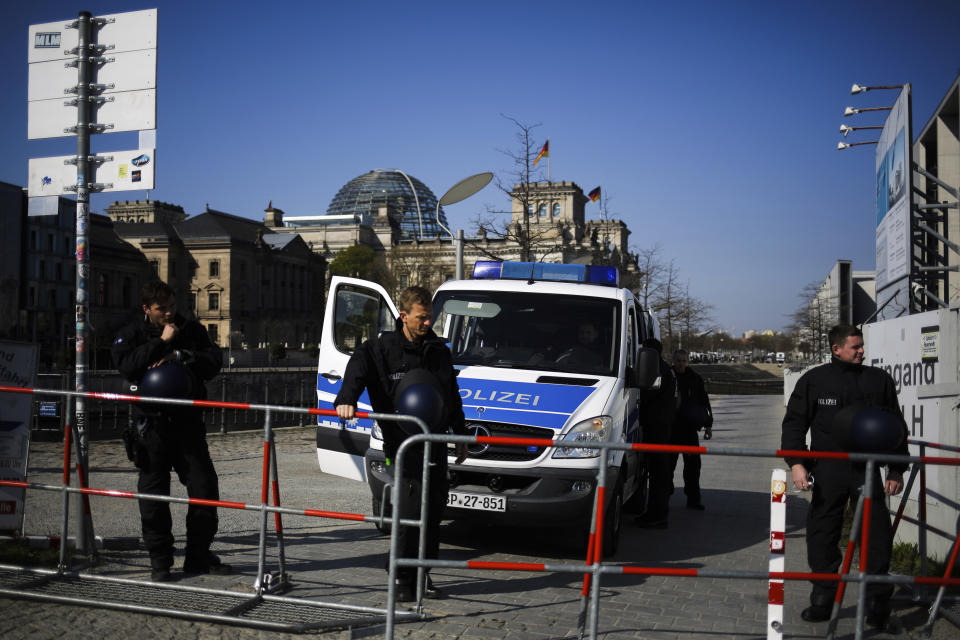 Police officers secure the German parliament, the Reichstag building prior to a protest rally against the government's policy to battle the corona virus pandemic in Berlin, Germany, Wednesday, April 21, 2021. The parliament decides on a law that gives the federal government more power to battle the coronavirus pandemic. (AP Photo/Markus Schreiber)