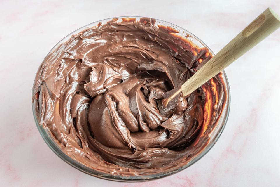 mixing thick chocolate mixture in a glass bowl