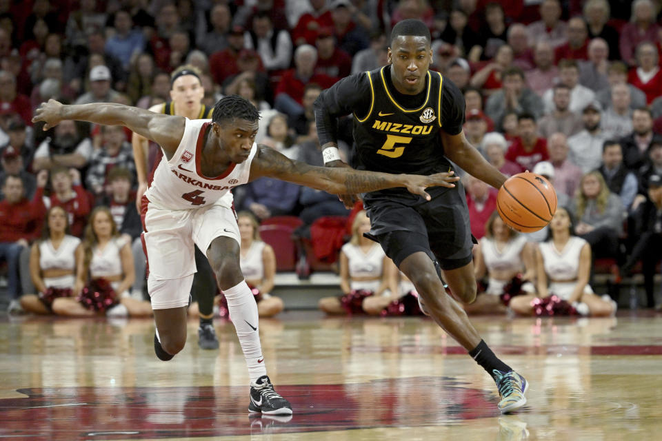 Missouri guard D'Moi Hodge (5) tries to get past Arkansas guard Davonte Davis (4) during the first half of an NCAA college basketball game Wednesday, Jan. 4, 2023, in Fayetteville, Ark. (AP Photo/Michael Woods)