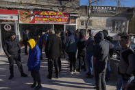 People line up outside a bakery to buy bread due the shortage of food in Kahramanmaras, southern Turkey, Tuesday, Feb. 7, 2023. A powerful earthquake hit southeast Turkey and Syria early Monday, toppling hundreds of buildings and killing and injuring thousands of people. (AP Photo/Khalil Hamra)