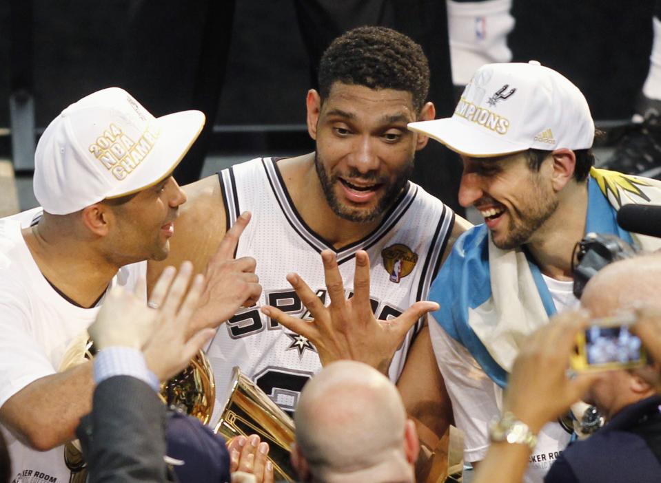 (L-R) San Antonio Spurs' Tony Parker of France, Tim Duncan, and Manu Ginobili of Argentina hold the Larry O'Brien trophy and gesture five fingers for Duncan's five championships after the Spurs defeated the Miami Heat in Game 5 of their NBA Finals basketball series in San Antonio, Texas, June 15, 2014. REUTERS/Mike Stone (UNITED STATES - Tags: SPORT BASKETBALL)