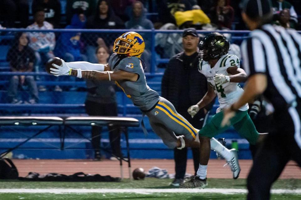 Grant’s Kingston Lopa (2) leaps to make a first down catch past Monterey Trail’s Hasaan Miller (24) during the second quarter in the game Friday, Oct. 21, 2022, at Grant High School in Sacramento.