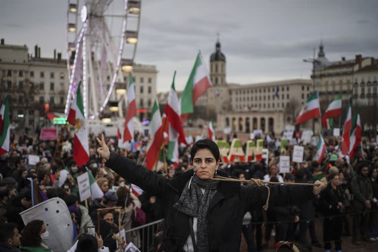 Una mujer posa con una cuerda alrededor del cuello durante una protesta en Lyon, en Francia, el domingo 8 de enero de 2023. (AP Foto/Laurent Cipriani)