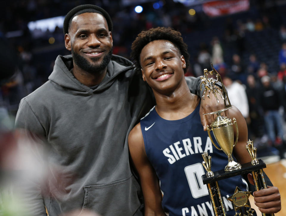 FILE - LeBron James, left, poses with his son Bronny after Sierra Canyon beat Akron St. Vincent - St. Mary in a high school basketball game, Saturday, Dec. 14, 2019, in Columbus, Ohio. Bronny James, son of NBA superstar LeBron James, was hospitalized after going into cardiac arrest while participating in a practice at Southern California on Monday, July 24, 2023. (AP Photo/Jay LaPrete, File)