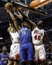 Chicago Bulls' Taj Gibson (22) and Nazr Mohammed (48) put defensive pressure on Orlando Magic's Gustavo Avon during an NBA basketball game in Chicago on Tuesday, Nov. 6, 2012.(AP Photo/Charles Cherney)